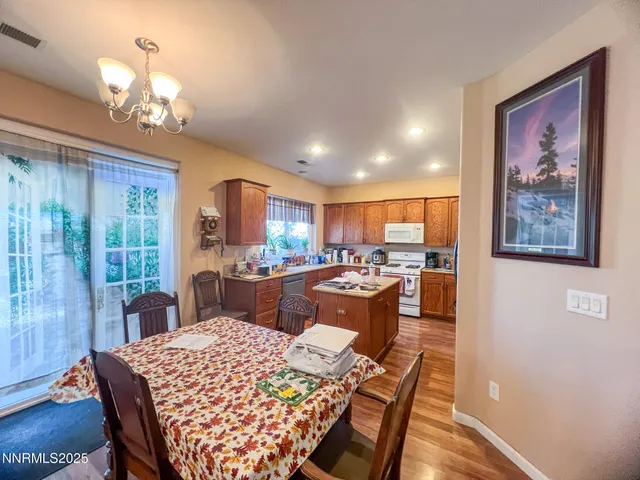 a view of a dining room with furniture a chandelier and wooden floor