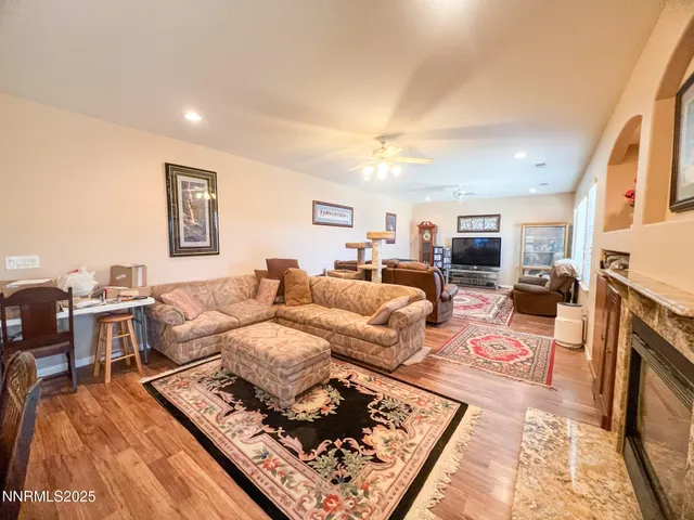 a living room with furniture hard wood floor and a fireplace