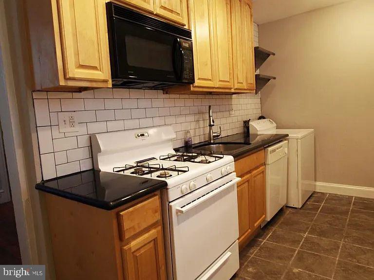 4335 Fleming Street Philadelphia, PA 19128 - Photo 2 of 19 a kitchen with granite countertop a stove top oven microwave and cabinets