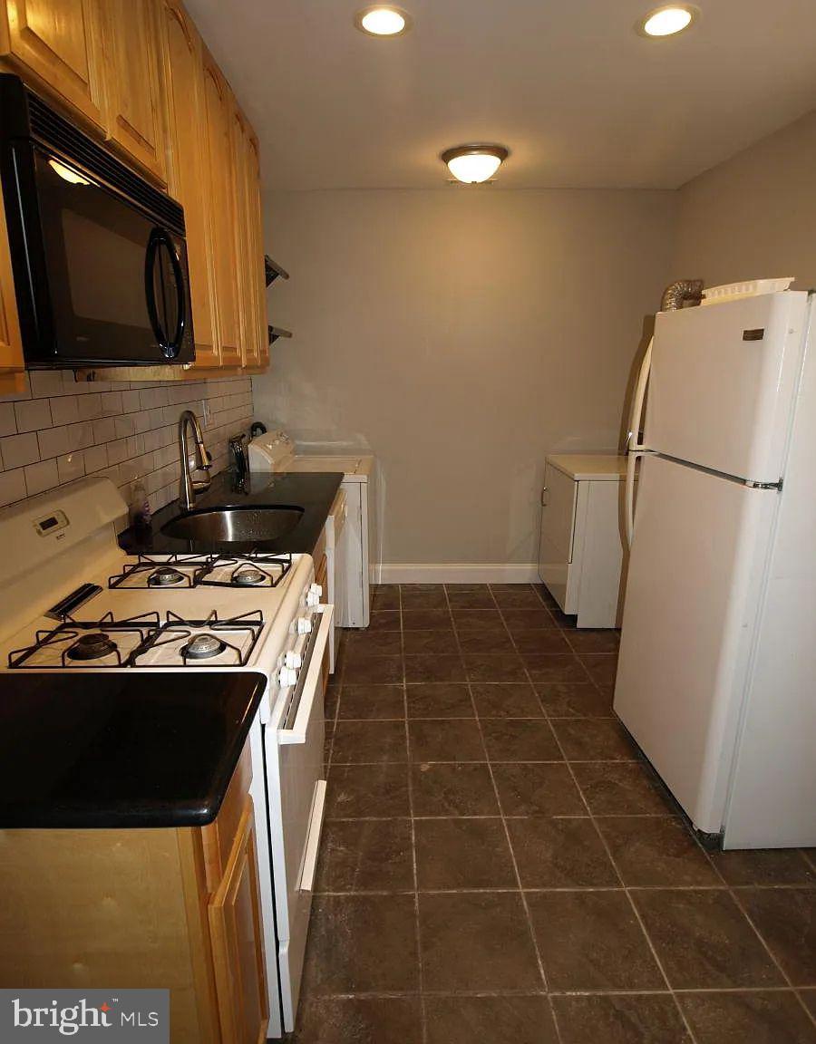 4335 Fleming Street Philadelphia, PA 19128 - Photo 3 of 19 a kitchen with a sink a stove and refrigerator