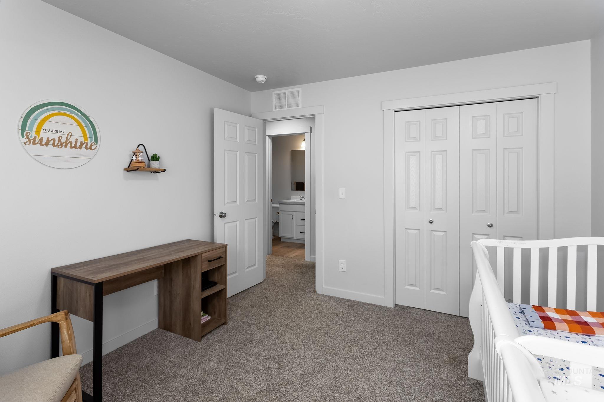 12771 Carkhill Street Caldwell, ID 83607 - Photo 11 of 13 Carpeted room with a bi-fold closet, a white panel door, and a partially visible wood-finish desk