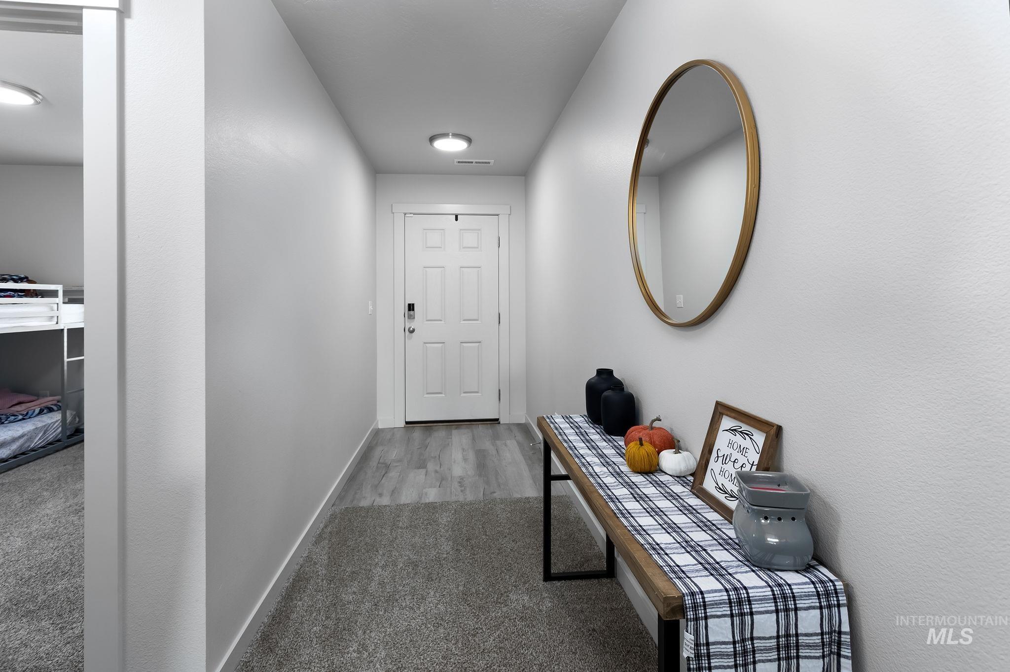 12771 Carkhill Street Caldwell, ID 83607 - Photo 3 of 13 Entryway featuring a paneled door with smart lock, wood-finish flooring, and flush-mount lighting