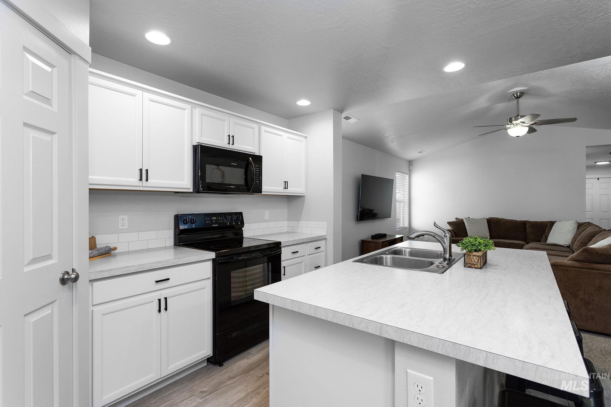 12771 Carkhill Street Caldwell, ID 83607 - Photo 6 of 13 Kitchen island with integrated double basin stainless steel sink and gooseneck faucet
