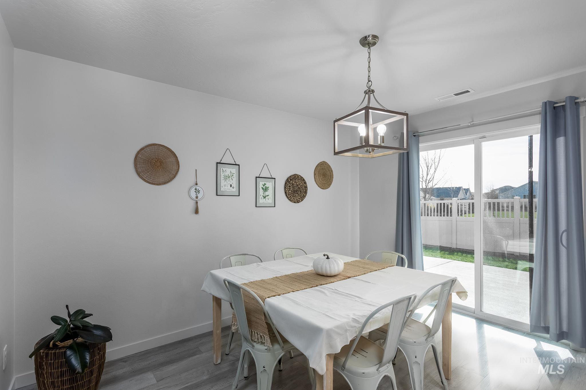 12771 Carkhill Street Caldwell, ID 83607 - Photo 9 of 13 Dining area featuring wood-finish flooring and a contemporary linear chandelier