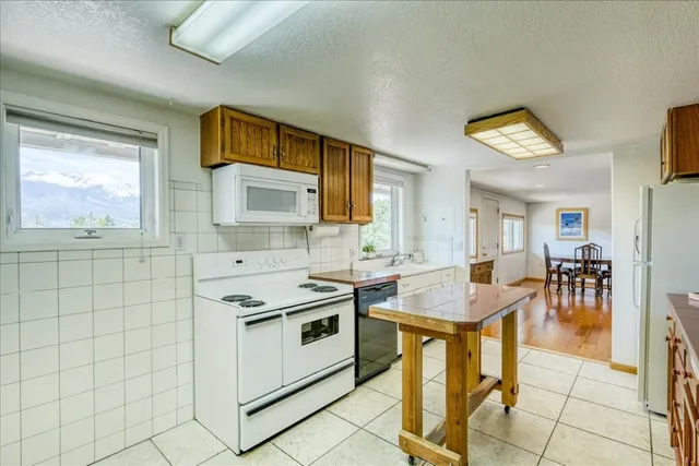 a kitchen with stainless steel appliances granite countertop a stove a sink a dining table and chairs