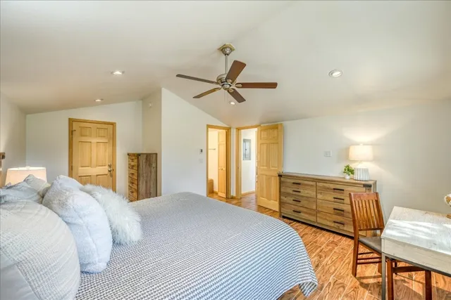 a bedroom with a bed a ceiling fan and a dresser