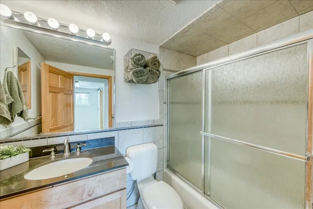 a bathroom with a granite countertop sink toilet and shower