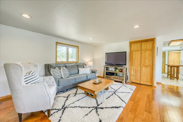 a living room with furniture a flat screen tv and a table