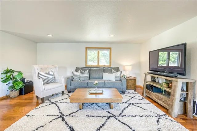a living room with furniture a flat screen tv and a window