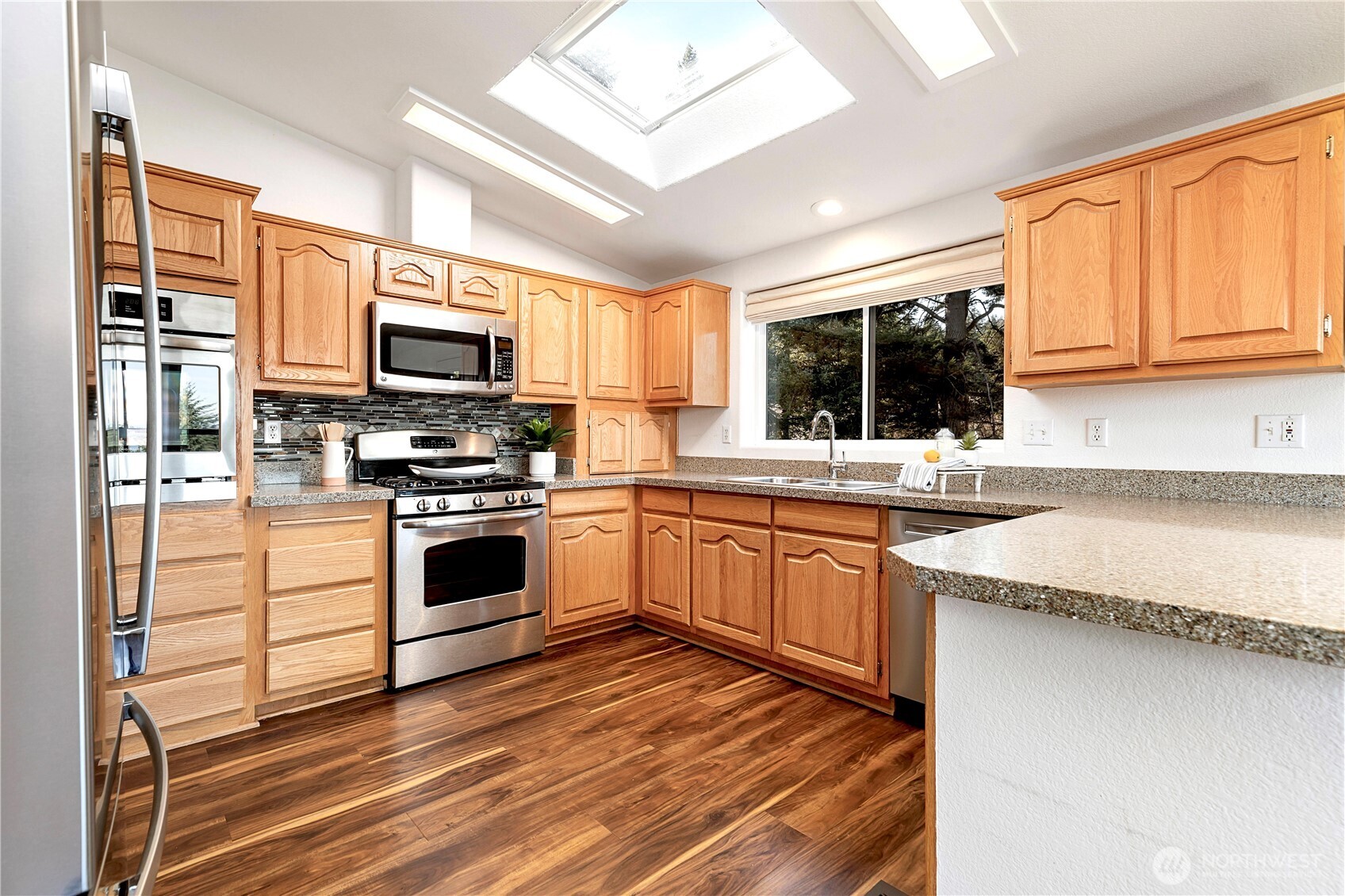 3834 South Passage View Lane Langley, WA 98260 - Photo 20 of 40 a kitchen with granite countertop a stove a sink and a microwave