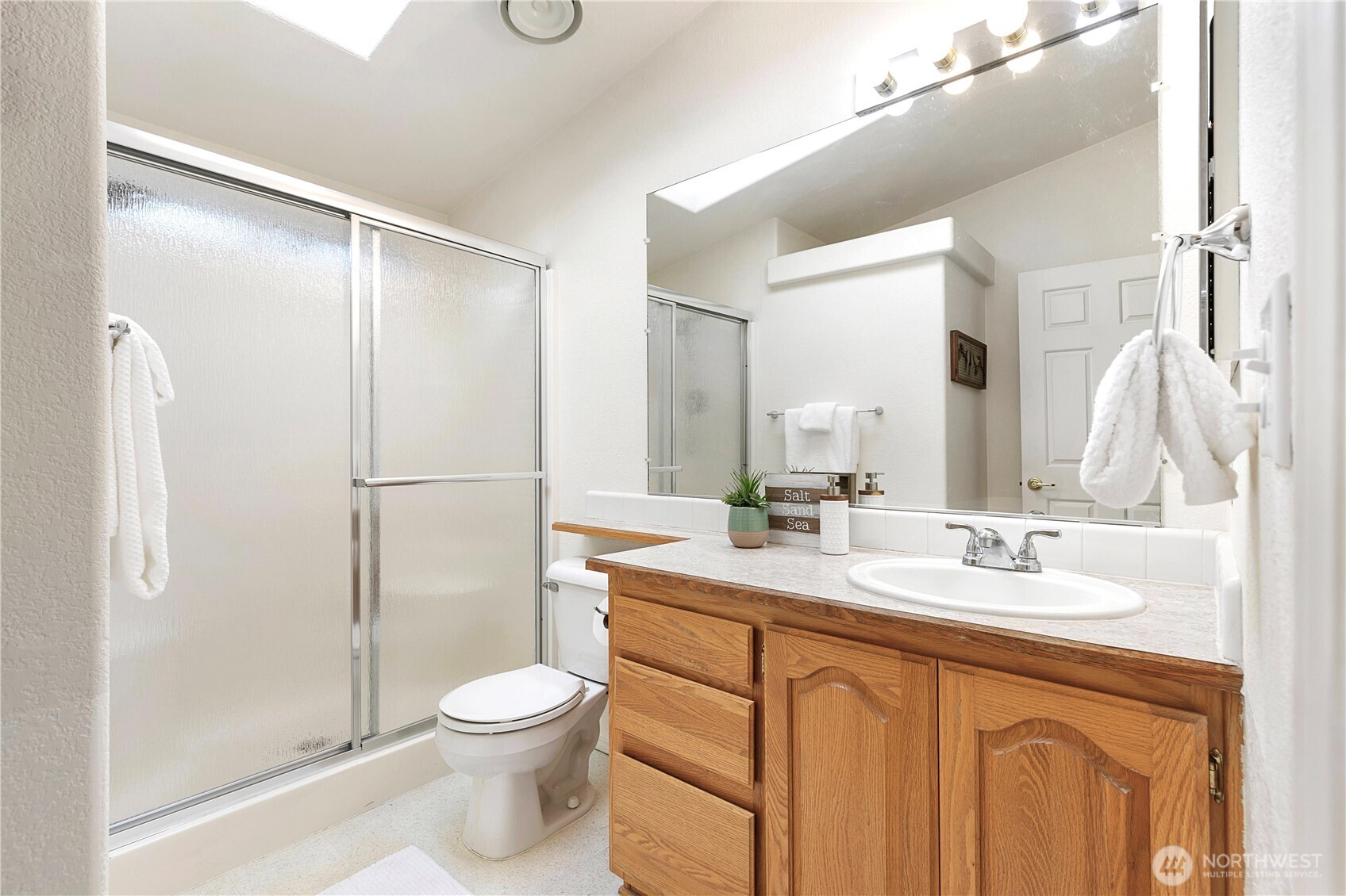3834 South Passage View Lane Langley, WA 98260 - Photo 32 of 40 a bathroom with a granite countertop sink toilet a mirror and shower