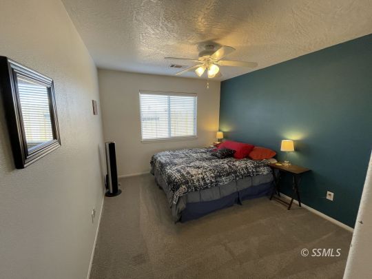 1411 Sims Street Ridgecrest, CA 93555 - Photo 19 of 35 a bedroom with a bed and a chandelier