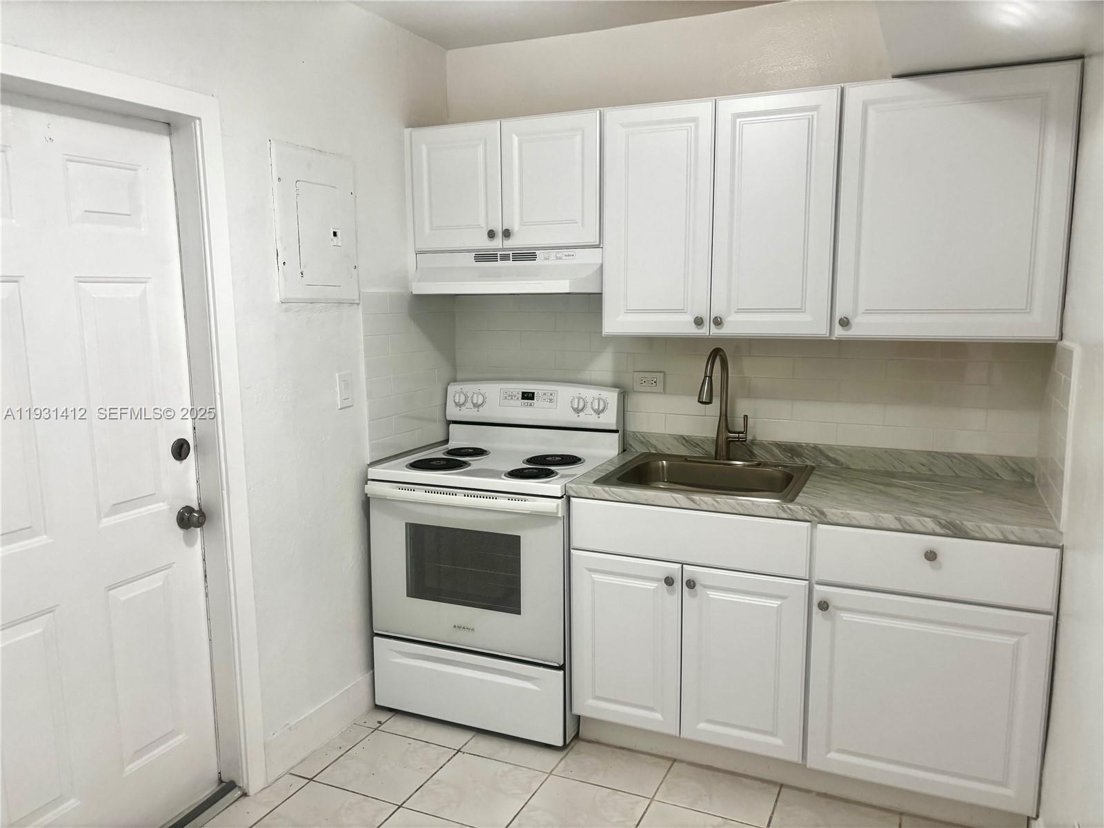 14731 Harding Lane Homestead, FL 33033 - Photo 4 of 10 a kitchen with white cabinets and white appliances
