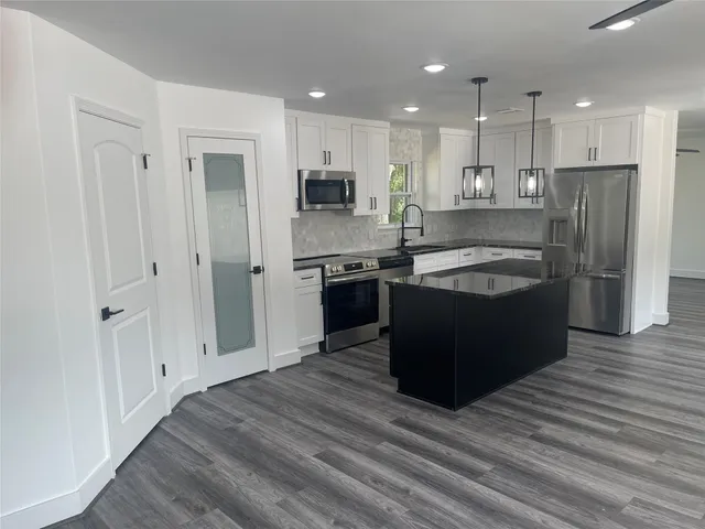 a kitchen with stainless steel appliances granite countertop a stove and a refrigerator