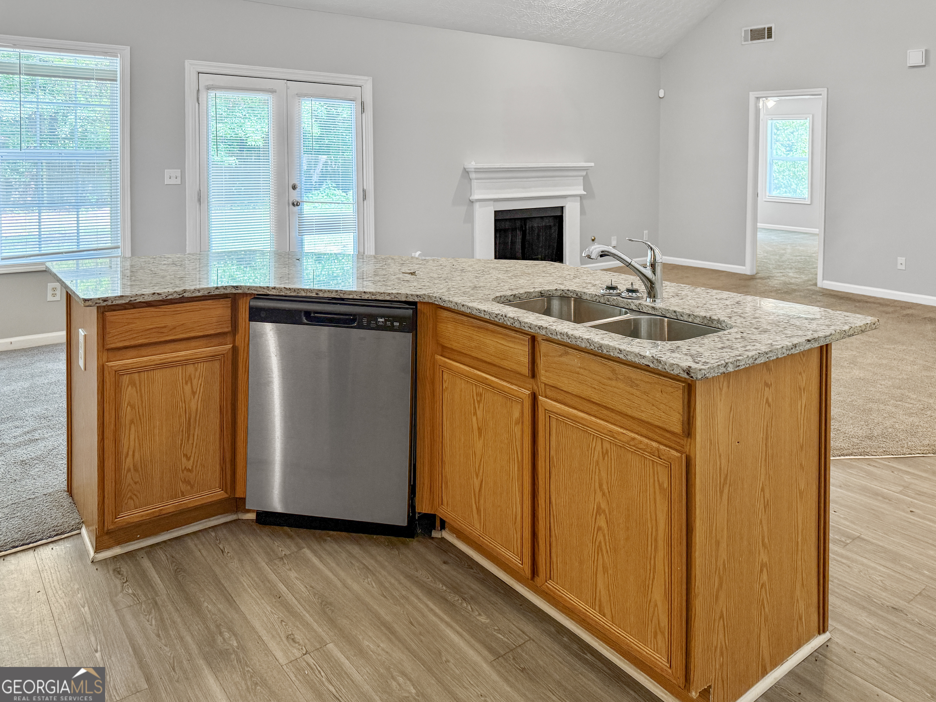 9108 South Sterling Lakes Drive Covington, GA 30014 - Photo 7 of 16 an open kitchen with granite countertop a sink and a stove with wooden floor
