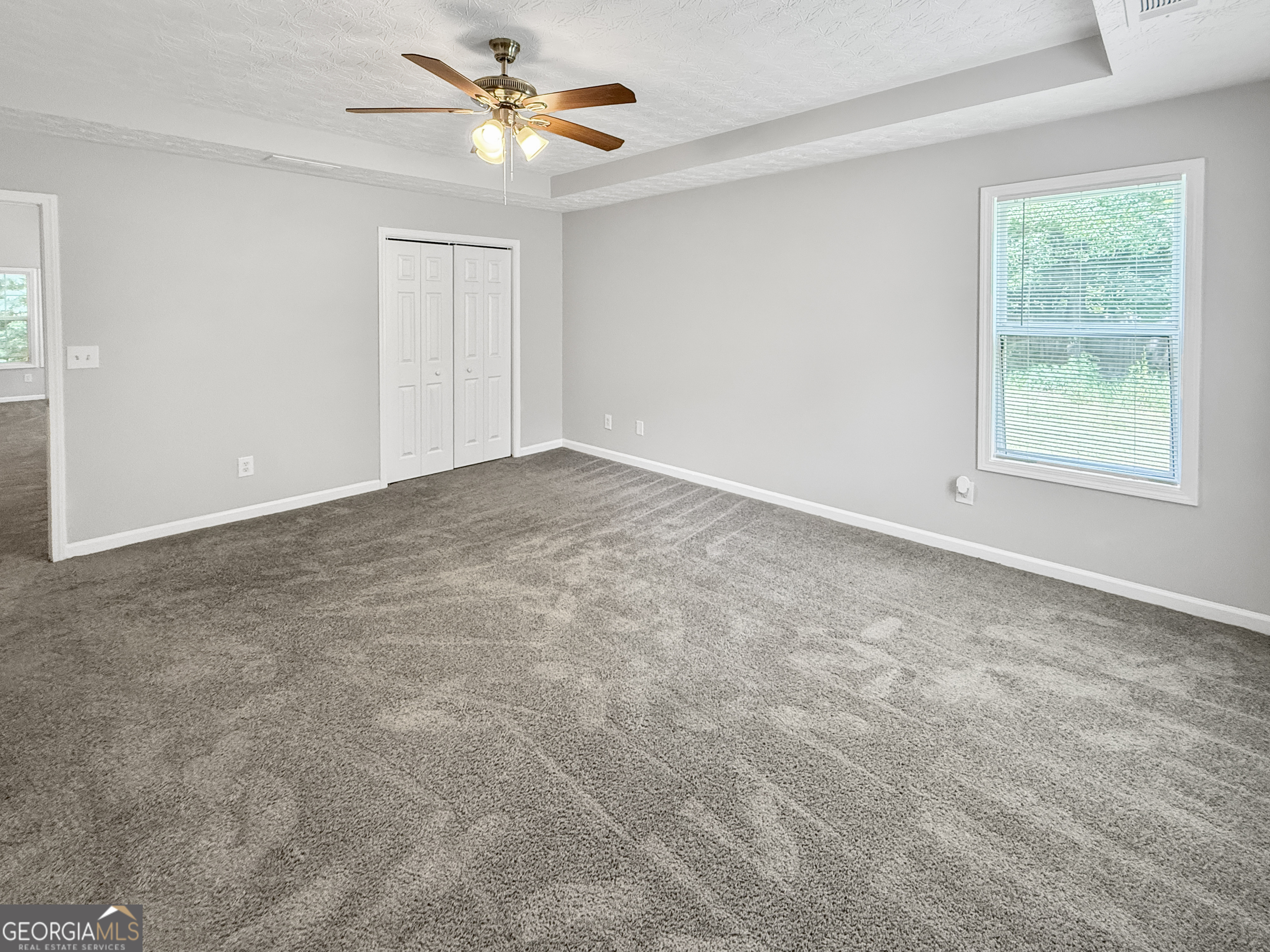 9108 South Sterling Lakes Drive Covington, GA 30014 - Photo 8 of 16 an empty room with windows and fan