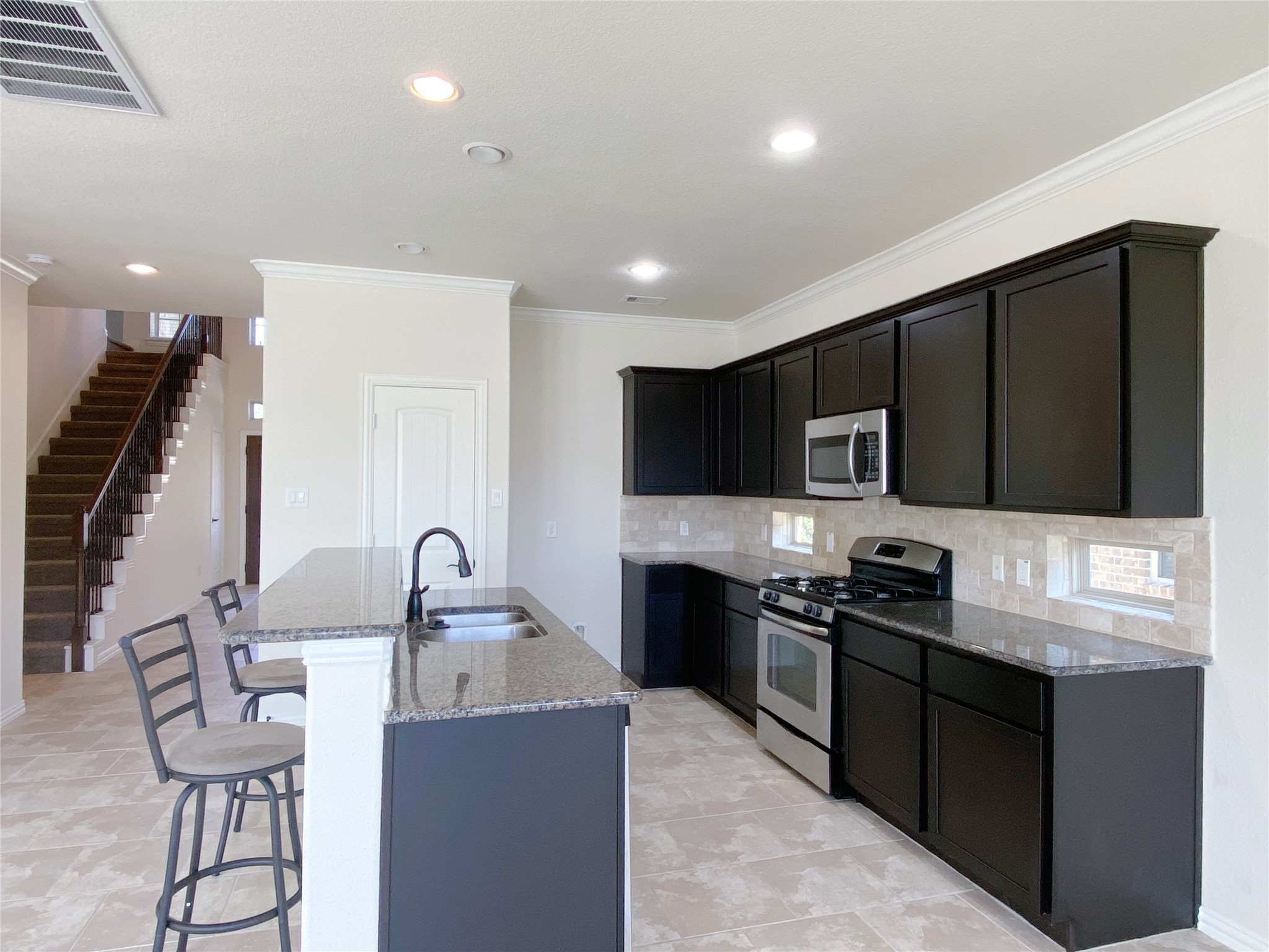 3566 Hamilton Bend Lane Spring, TX 77386 - Photo 11 of 25 a kitchen with stainless steel appliances kitchen island granite countertop a stove a sink a microwave a refrigerator and cabinets