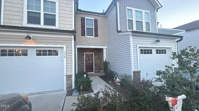 a front view of a house with a yard and potted plants