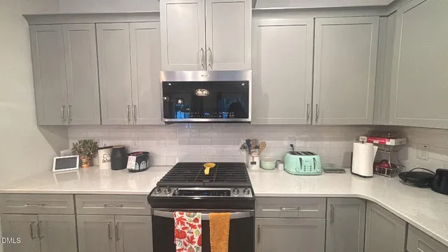 a kitchen with stainless steel appliances granite countertop a sink a stove and cabinets