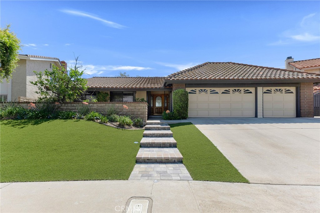 19252 Pebble Beach Place Porter Ranch, CA 91326 - Photo 1 of 1 a front view of a house with a garden