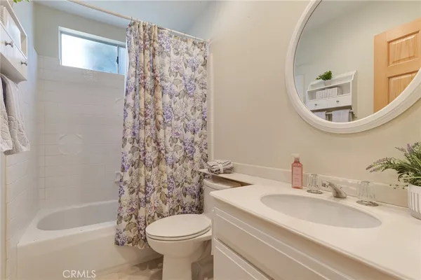 a view of an empty room with cabinet and mirrors