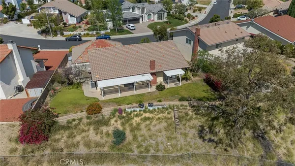 an aerial view of residential house with outdoor space and trees all around