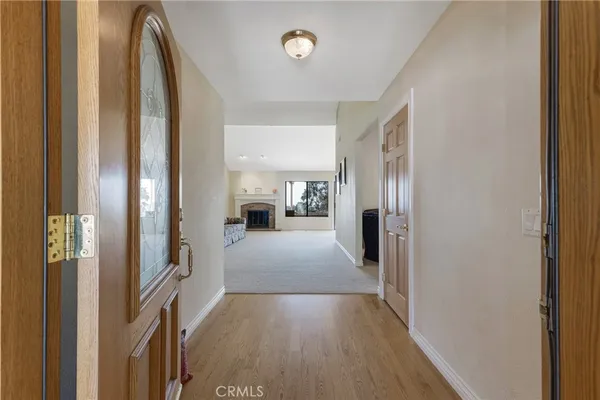 a view of a hallway with wooden floor and a living room