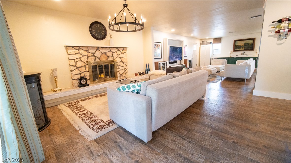 425 Blackridge Road Henderson, NV 89015 - Photo 7 of 31 Warm wood-look tile floors and a rustic stone fireplace anchor this open-concept living space.