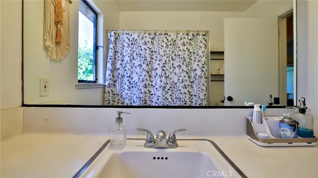 a bathroom with a bathtub sink and mirror