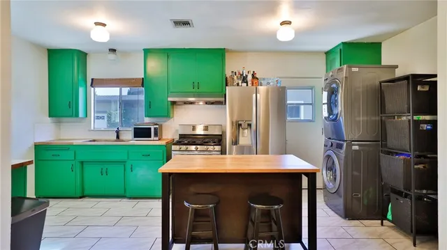 a kitchen with kitchen island a refrigerator and a sink
