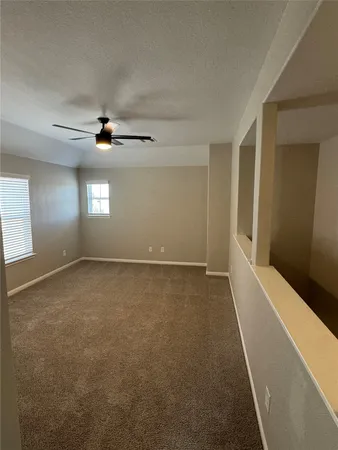 an empty room with windows and fan