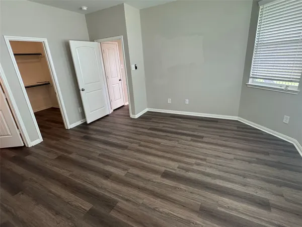 an empty room with wooden floor and entrance