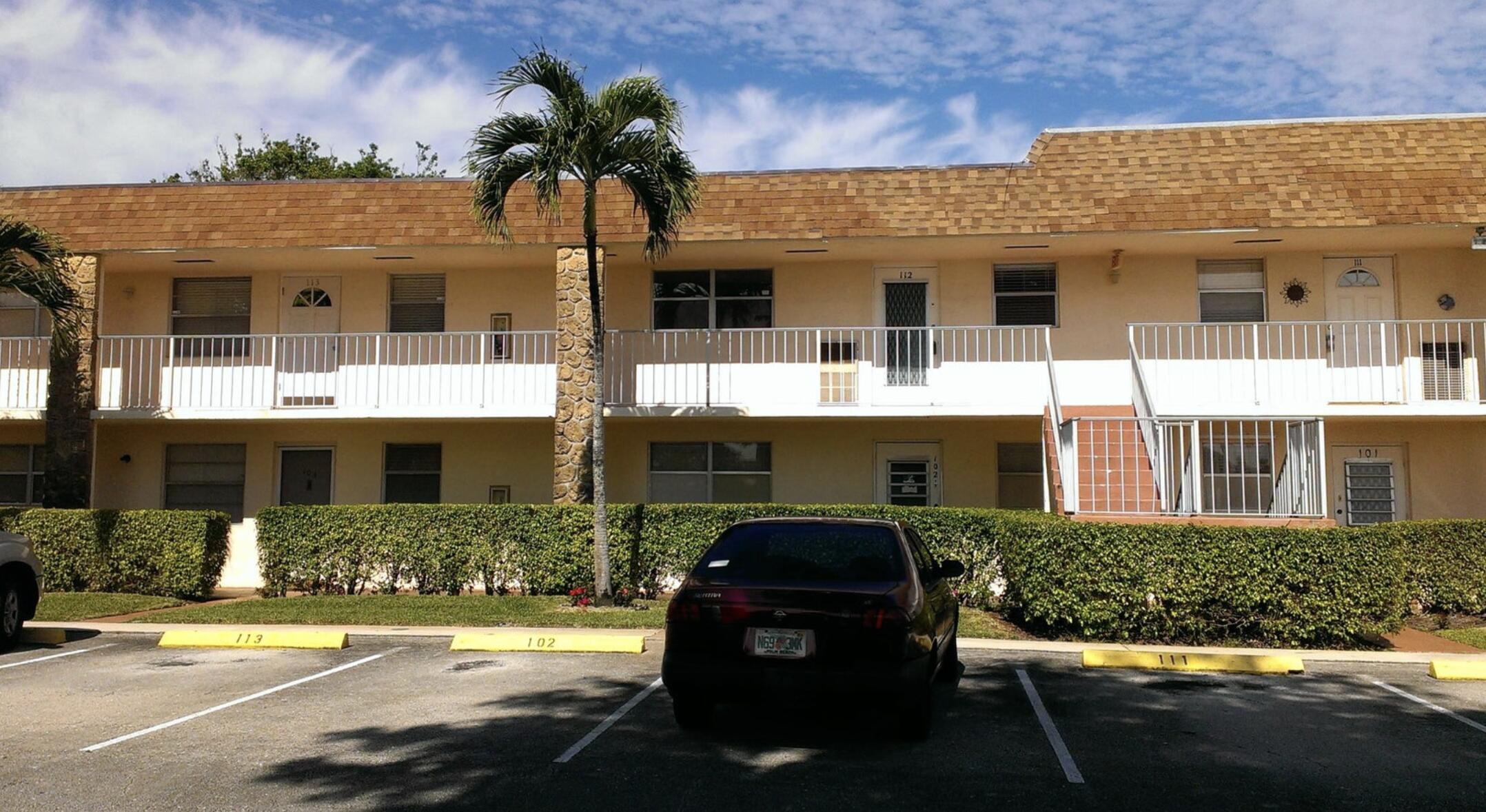 a front view of a house with a yard and potted plants