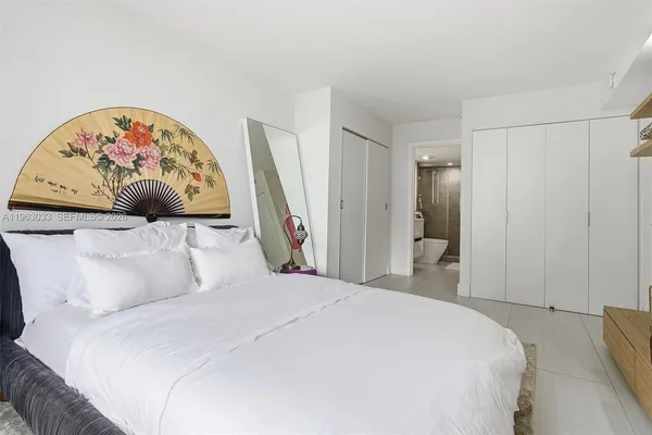 a bedroom with a large bed and a chair