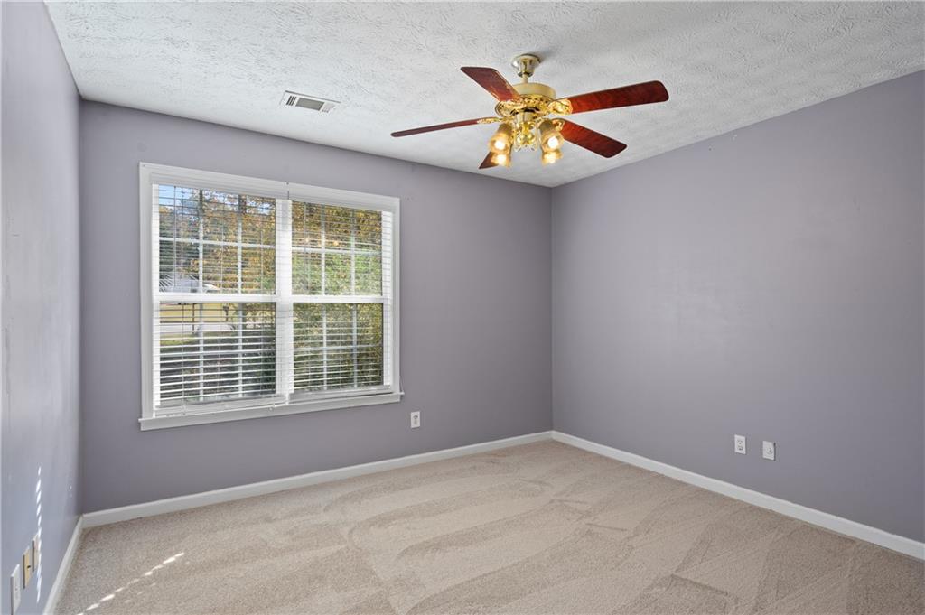 201 Nina Circle Locust Grove, GA 30248 - Photo 21 of 48 a view of an empty room with a window and a ceiling fan