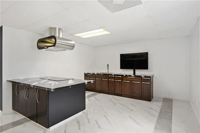 a kitchen with a sink and a flat screen tv