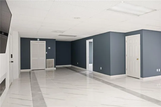 a view of an empty room with kitchen and sink