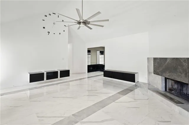 a view of an empty room with chandelier fan
