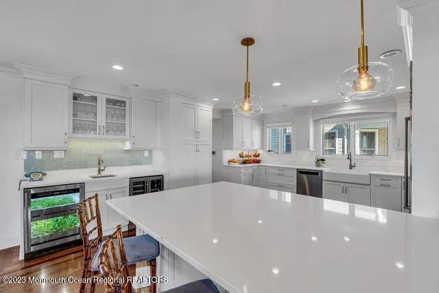 a large kitchen with kitchen island a stove a sink a dining table and chairs with wooden floor