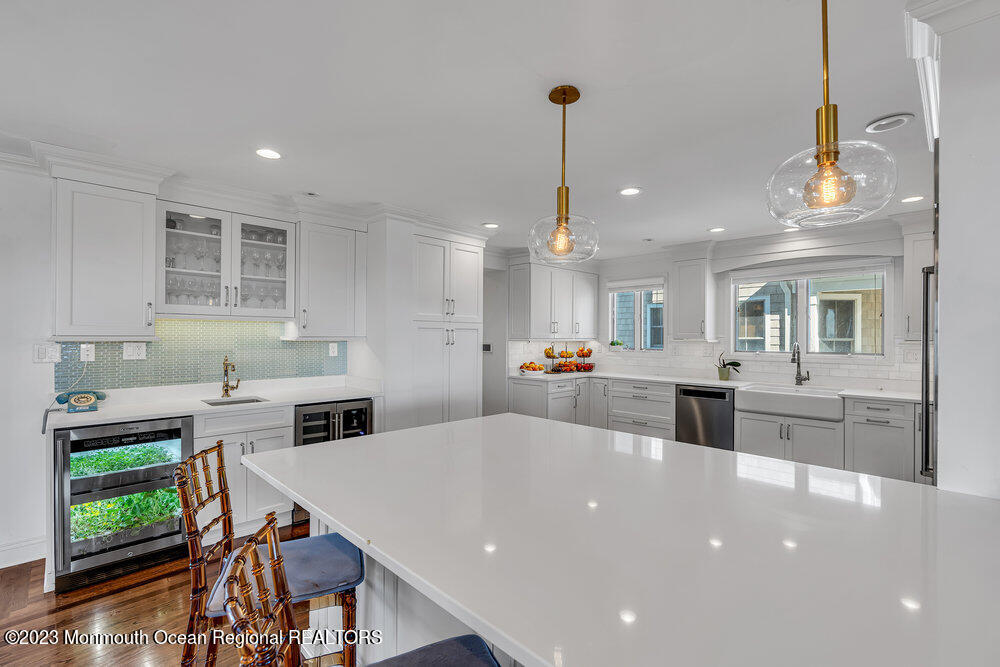 1609 Ocean Avenue Spring Lake, NJ 07762 - Photo 15 of 30 a large kitchen with kitchen island a stove a sink a dining table and chairs with wooden floor