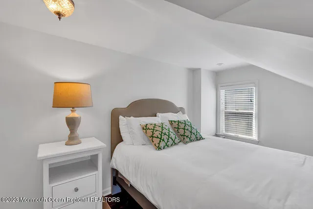 a bedroom with a bed and painting on the wall