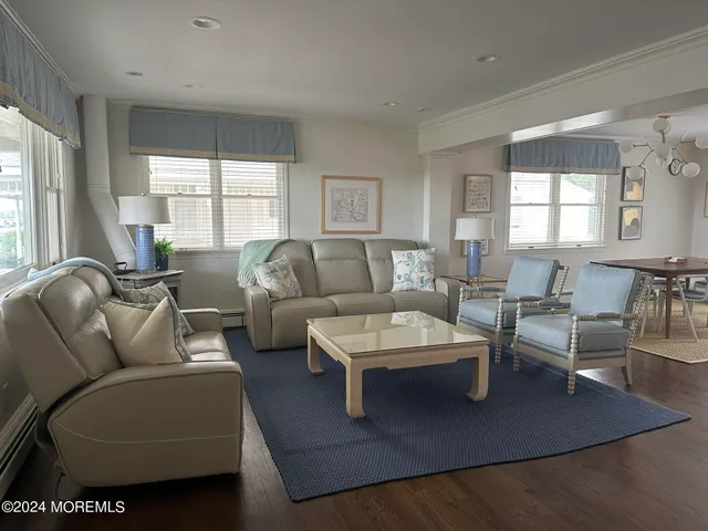 a living room with furniture wooden floor and a large window