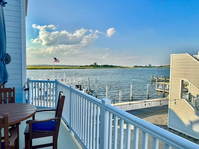 a view of a balcony with wooden chairs and floor to ceiling window
