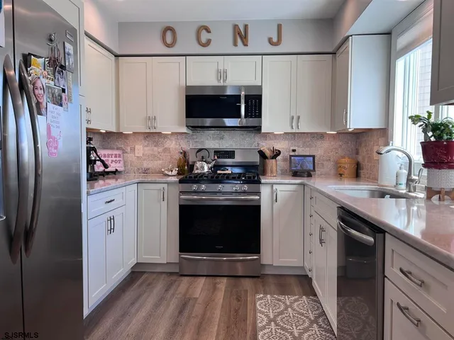 a kitchen with stainless steel appliances a stove a sink and a microwave