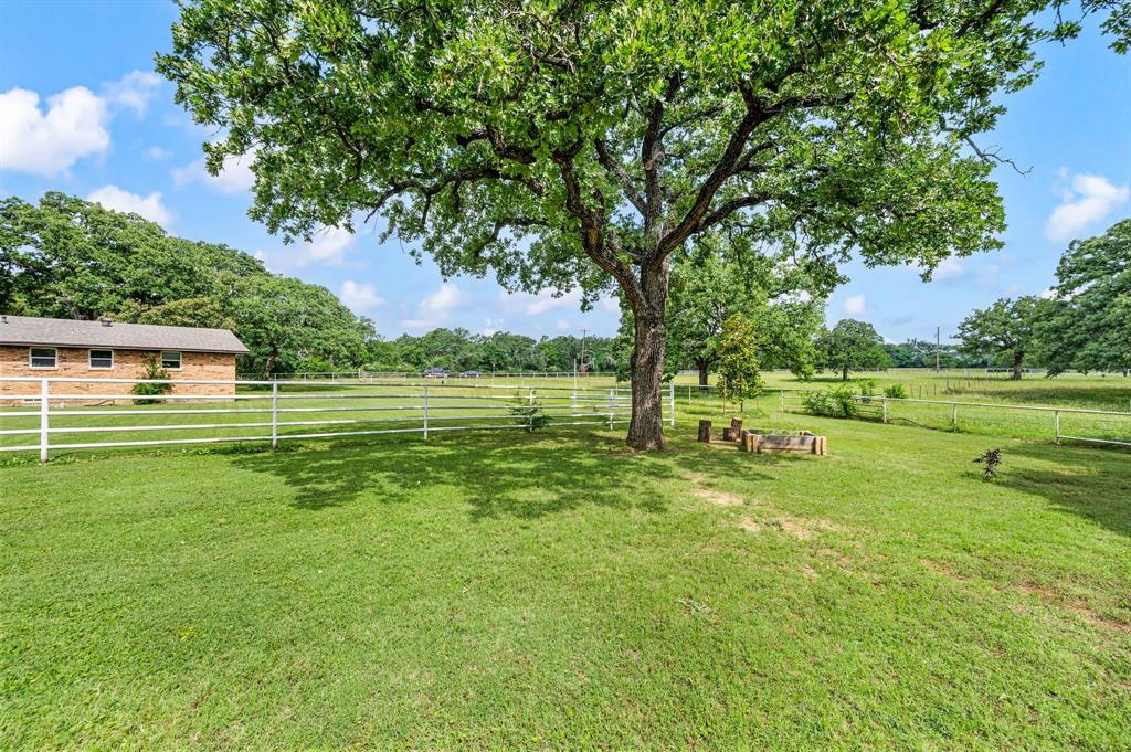 3900 Moseley Road Cross Roads, TX 76227 - Photo 27 of 36 Expansive green lawn with mature trees and a white perimeter fence