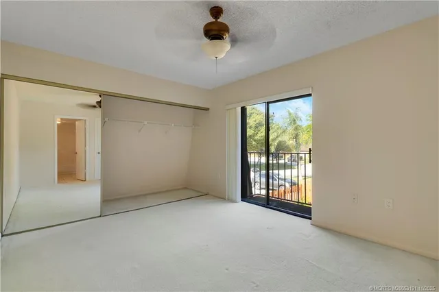 an empty room with a ceiling fan and a window