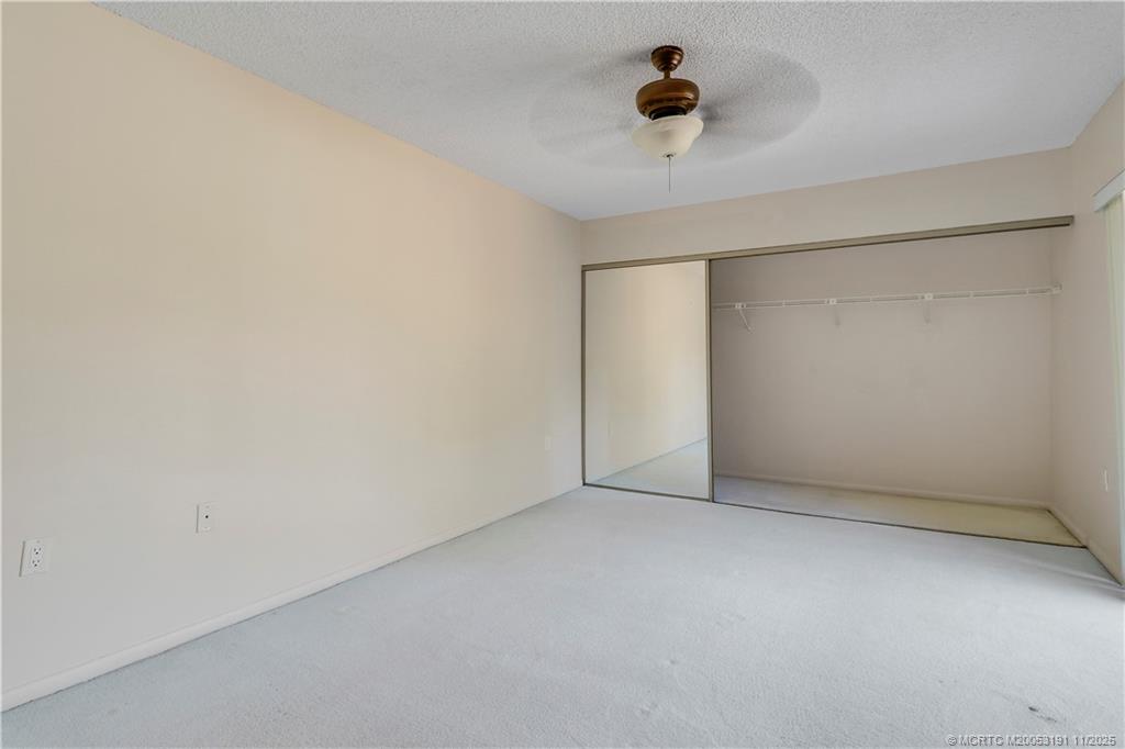 5662 Southeast Windsong Lane, Unit 408 Stuart, FL 34997 - Photo 31 of 35 an empty room with a ceiling fan and a window