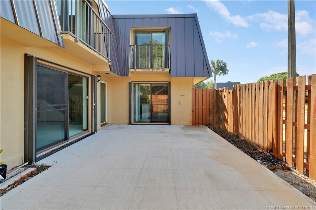 5662 Southeast Windsong Lane, Unit 408 Stuart, FL 34997 - Photo 32 of 35 a view of a house with a door and wooden fence