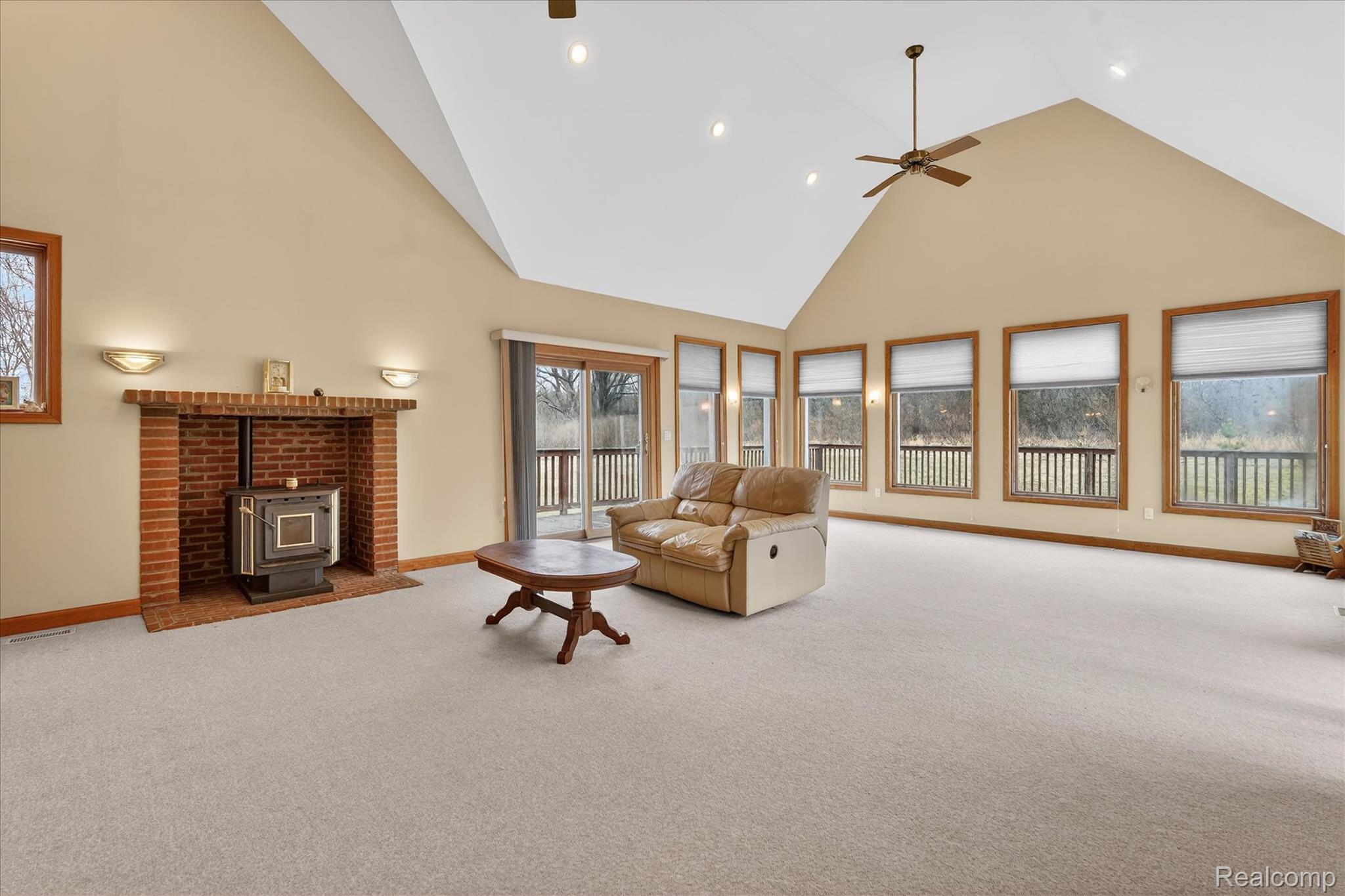 5640 Fisher Road Howell, MI 48855 - Photo 13 of 66 Carpeted living room with a wood stove, lofted ceiling, ceiling fan, and recessed lighting