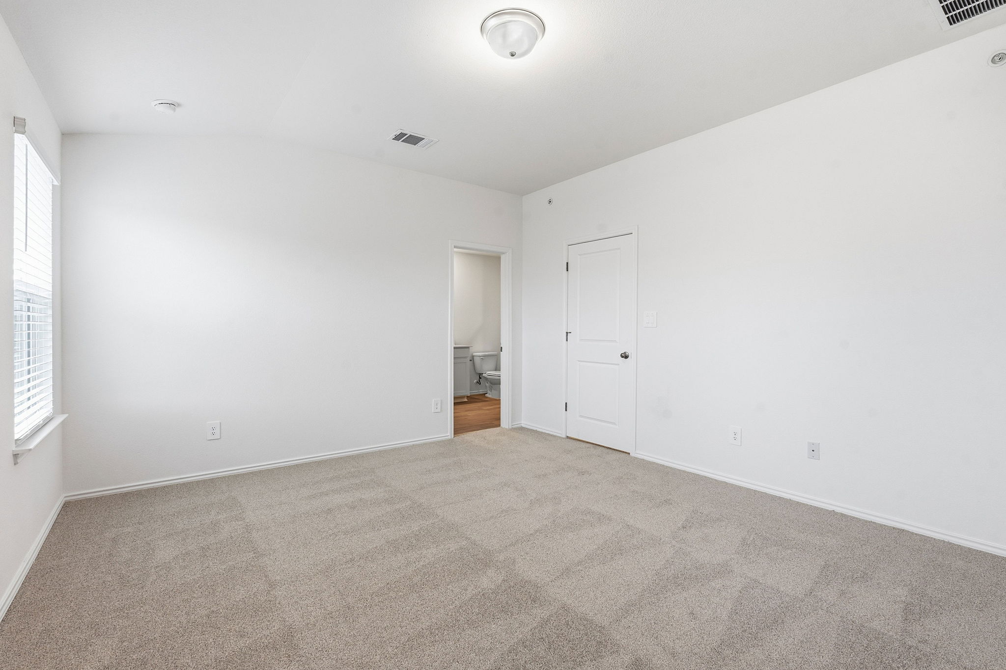 164 Cinnabar Lane, Unit 2 Kyle, TX 78640 - Photo 11 of 21 Room featuring neutral-toned carpet, a window with blinds, and white walls